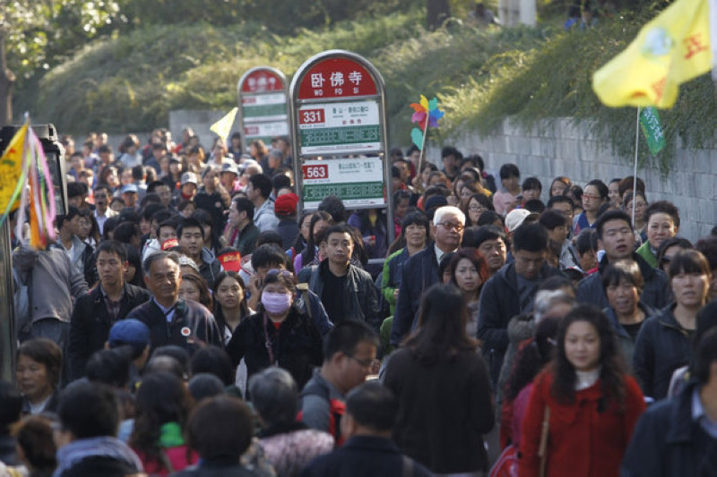 Une foule de visiteurs attend à un arrêt de bus à côté du Parc des Collines Parfumées à Beijing après une visite dans le parc, le 26 octobre.
