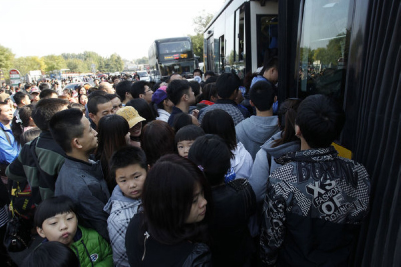 Des visiteurs s'engouffrent un bus à l'extérieur du Parc des Collines Parfumées à Beijing après une visite dans le parc, le 26 octobre.