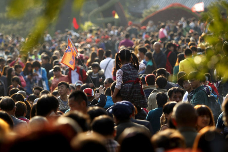 Une fillette assise sur les épaules de sa mère pour éviter la foule au Parc des Collines Parfumées à Beijing, le 26 octobre.
