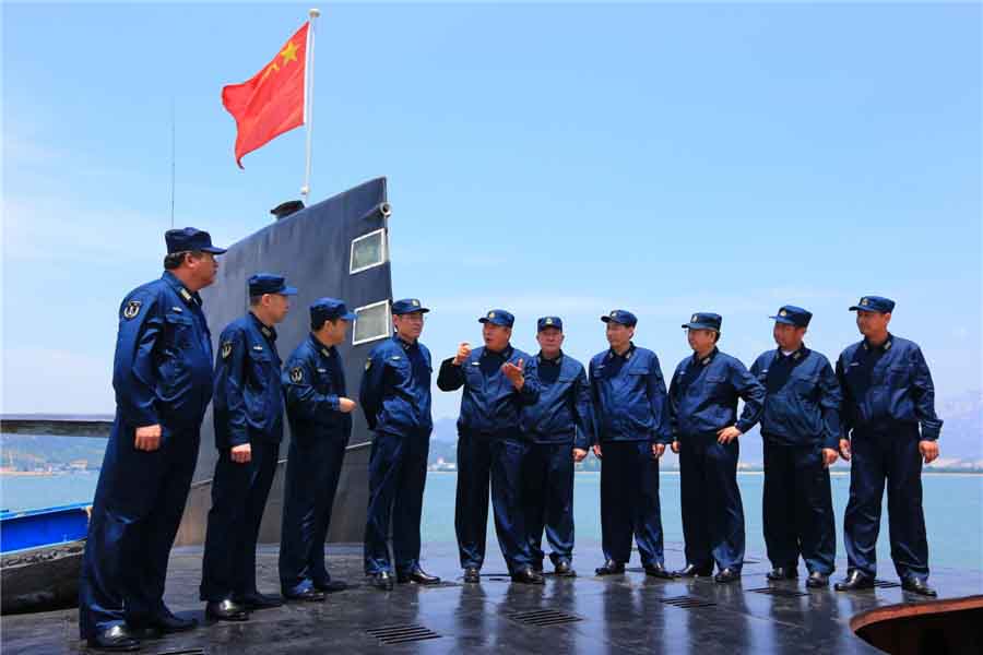 Des membres du Comité du Parti de la première force de sous-marins à propulsion nucléaire de la marine chinoise contrôlent les équipements à Qingdao, dans la Province du Shandong en Chine de l'Est, le 27 octobre 2013.