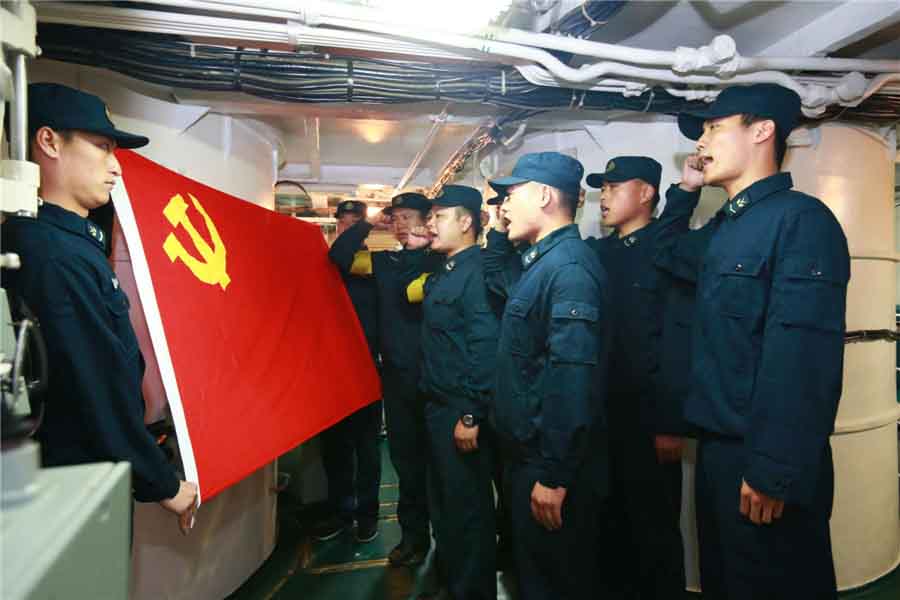 Des marins de la première force de sous-marins à propulsion nucléaire de la marine chinoise prononcent un serment devant le drapeau du Parti à Qingdao, dans la Province du Shandong, en Chine de l'Est, le 27 octobre 2013.