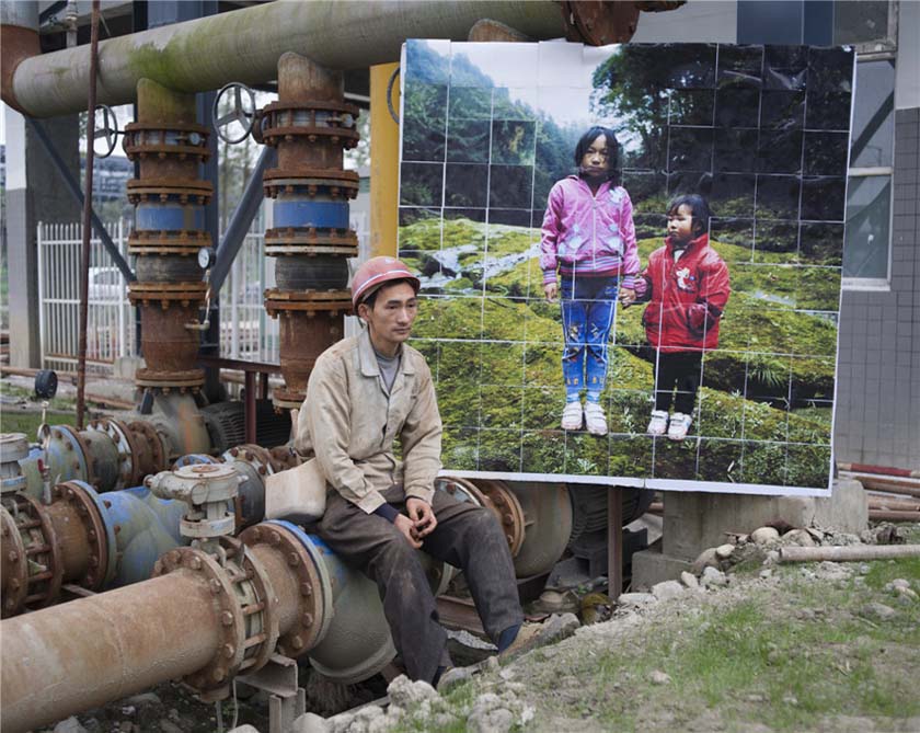 Sur le chantier de construction Foxconn dans le Comté de Pixian, dans la ville de Chengdu, dans la Province du Sichuan : Hou Keming du village de Houzhai de la commune de Xiema, dans le comté de Jiajiang, dans la ville de Leshan, dans la Province du Sichuan est assis à côté de la photo de ses deux filles (pris le 6 décembre 2011). Hou Keming a 35 ans, et il a laissé ses deux filles et son épouse en 2006 pour travailler au loin. Il a dit qu'il a dû laisser sa femme à la maison pour s'occuper de ses deux enfants et de ses parents, et qu'il ferait venir sa femme dans l'avenir, lorsque les deux enfants auront grandi. Photo Liu Jie. Fourni au China Daily