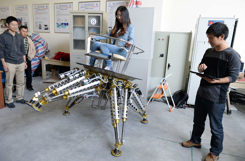 Lundi 28 octobre, dans un laboratoire de l'Institut d'ingénierie mécanique de l'Université Jiaotong de Shanghai, une membre de l'équipe à bord du « Poulpe à six bras » pour un essai. (Photo : Xinhua/Lai Xinlin)