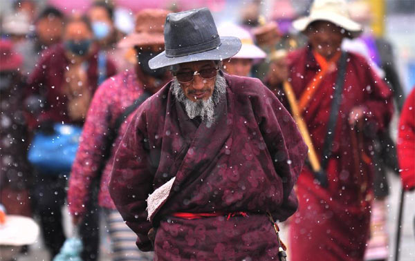 Un homme âgé marche dans la neige à Lhassa, capitale de la région autonome du Tibet dans le sud de la Chine, le 28 octobre 2013. Des chutes de neige ont touché de nombreuses régions au Tibet lundi. [Photo/Xinhua ]