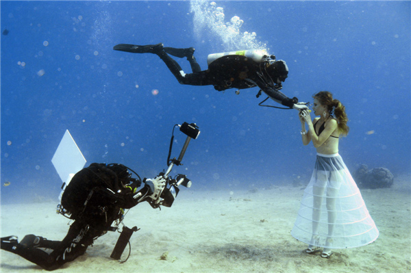 Un mannequin ouvre la bouche pour respirer avec une bouteille de plongée alors que le photographe israélien Johannes Felten (à gauche) prend des photos au cours d'une séance de photos sous-marines en Mer Rouge au large de la ville balnéaire d'Eilat, le 22 octobre 2013. Une épave s'est révélée être un endroit populaire pour les prises de vue de cette année en Mer Rouge au large d'Eilat, où les photographes sous-marins du monde entier se sont précipités pendant trois jours pour capturer les meilleures images. [Photo / agences]