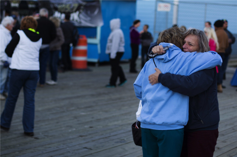 Deux femmes se rencontrent pour la première fois en un an alors qu'elles participent à une manifestation d'illumination de la côte pour le premier anniversaire de l'ouragan Sandy à Seaside Heights, dans le New Jersey, le 29 octobre 2013.