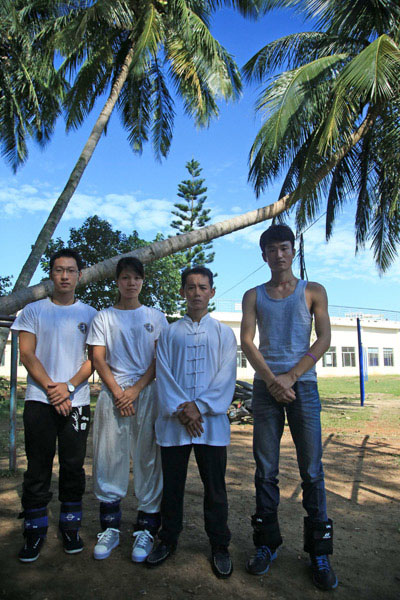 Le 30 octobre, Fu Chunfu (2ème à droite), un maître de Kung Fu, prend la pose avec ses apprentis sur le campus de l'Université de Hainan. Fu a commencé la pratique de cet art à l'âge de neuf ans et il a aujourd'hui plus de 40 apprentis. [photo: Ma Ke/Asianewsphoto]