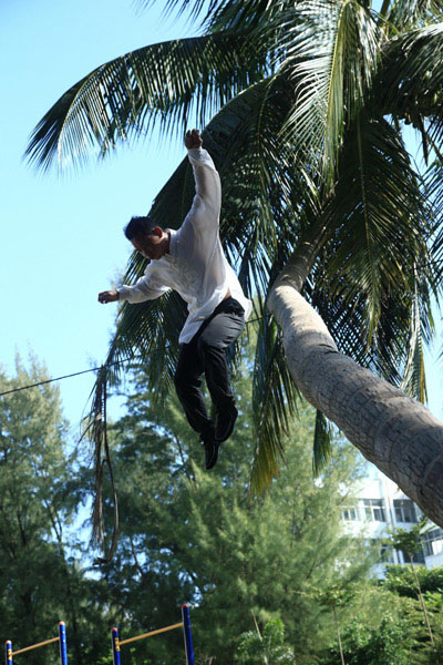 Fu Chunfu, un maître de Kung Fu, sur un arbre de noix de coco sur le campus de l'Université de Hainan, le 30 octobre. Fu est devenu une star sur les réseaux sociaux, où on le voit pratiquer le kung-fu dans les arbres.