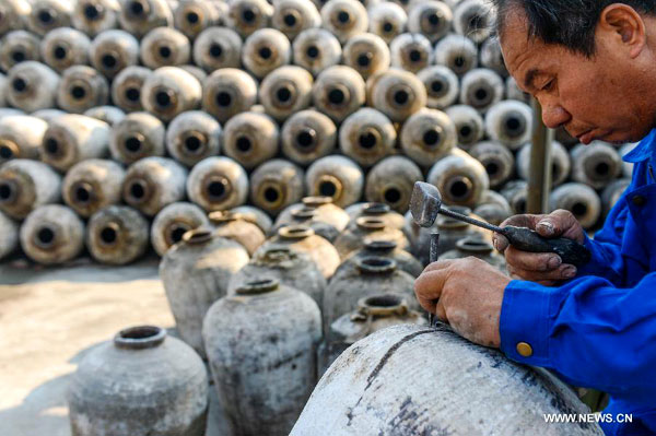 Un brasseur répare des conteneurs en céramique pour le brassage d'hiver annuel à la distillerie de Shenyonghe à Shaoxing, province du Zhejiang dans l'est de la Chine, le 30 octobre 2013.[Photo/Xinhua]