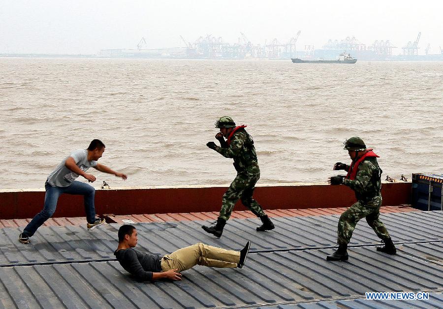 La police frontalière locale lutte avec deux «terroristes» au cours d'un exercice de sécurité visant à renforcer les capacités d'intervention sur les côtes, près de la nouvelle zone de libre-échange à Shanghai (Chine orientale), le 30 octobre 2013. [Photo/Xinhua/Chen Fei ]