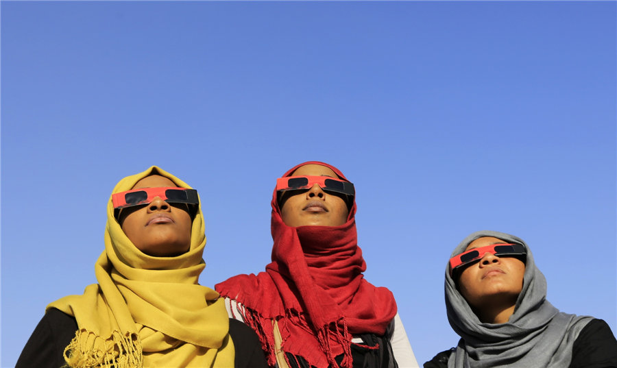 Des femmes observent une éclipse solaire lors d'un événement organisé par la Société soudanaise pour l'astronomie et les sciences spatiales sur les rives du Nil à Khartoum, au Soudan, le 3 novembre 2013. Les astronomes amateurs du monde entier ont été à la fête dimanche avec la dernière éclipse solaire de 2013, qui a pris une forme hybride rare.