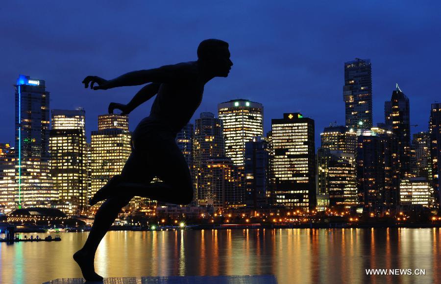 photo prise le 4 novembre 2013 montre la statue du célèbre coureur canadien Harry Winston Jerome et la vue sur le centre-ville depuis le parc Stanley de Vancouver, au Canada. (Xinhua/Sergei Bachlakov)