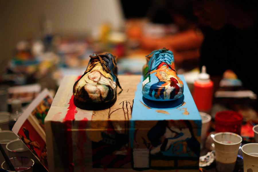 Les chaussures de Liu Bolin, un artiste chinois, sont photographiés avant qu'il les porte pour se fondre dans un décor, une étagère garnie de bandes dessinées, dans le cadre d’une série de spectacles à Caracas, le 1er novembre 2013.
