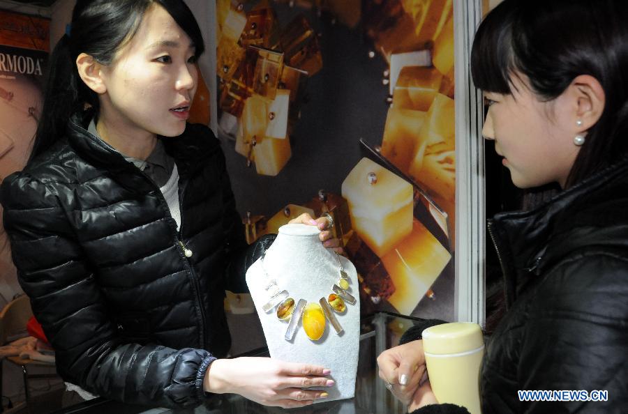 Une exposante présente un collier à une visiteuse lors du Salon international du bijou et de l'accessoire 2013 à Beijing. L'exposition d'une durée de quatre jours a débuté le 13 novembre 2013. [Photo / Xinhua]