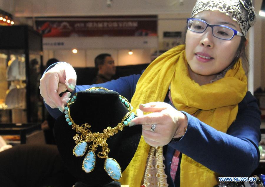Une exposante présente un collier lors du Salon international du bijou et de l'accessoire 2013 à Beijing. L'exposition d'une durée de quatre jours a débuté le 13 novembre 2013. [Photo / Xinhua]