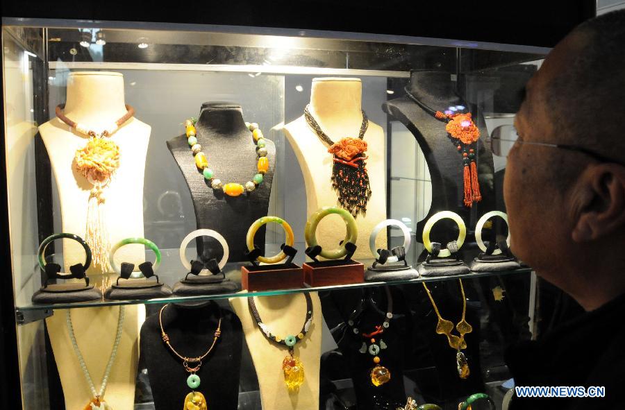 Un visiteur regarde des bijoux présentés lors du Salon international du bijou et de l'accessoire 2013 à Beijing. L'exposition d'une durée de quatre jours a débuté le 13 novembre 2013. [Photo / Xinhua]