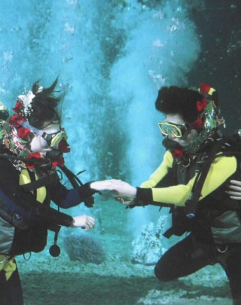 Le 13 décembre 1999, lors d'une cérémonie de mariage sous l'eau organisée dans un aquarium à Shanghai, Li Ming (à droite) et sa future femme Ni Ying s'échangent les anneaux nuptiaux. 
