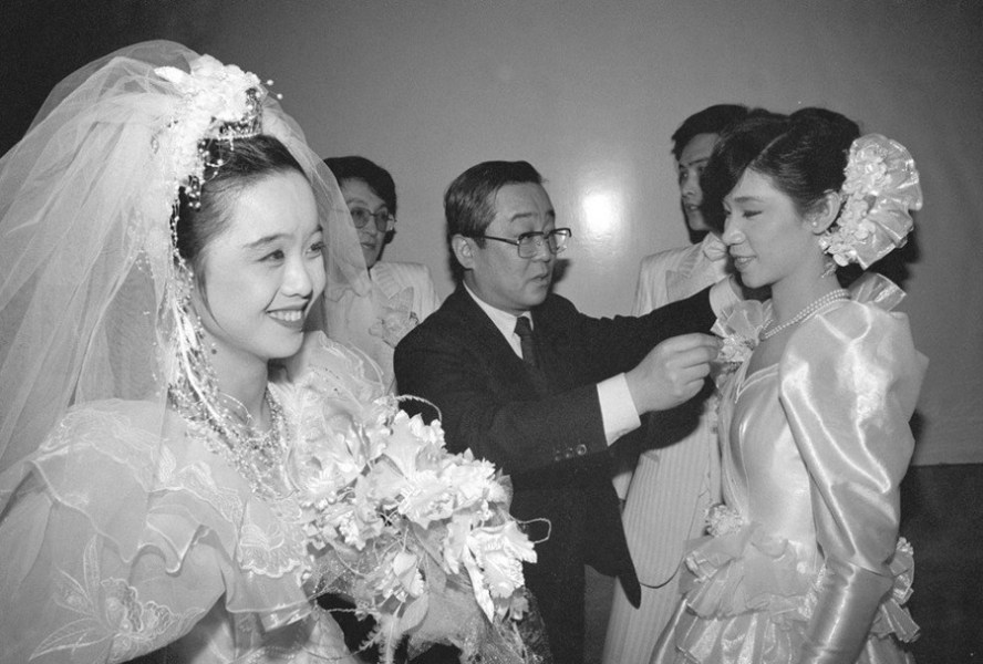Le 6 février 1988, Takasaki Kiichiro, un japonais spécialisé dans la photographie de cérémonies de mariage, examine les robes des jeunes mariées prêtes à participer à un mariage collectif dans le Palais culturel des Nationalités.