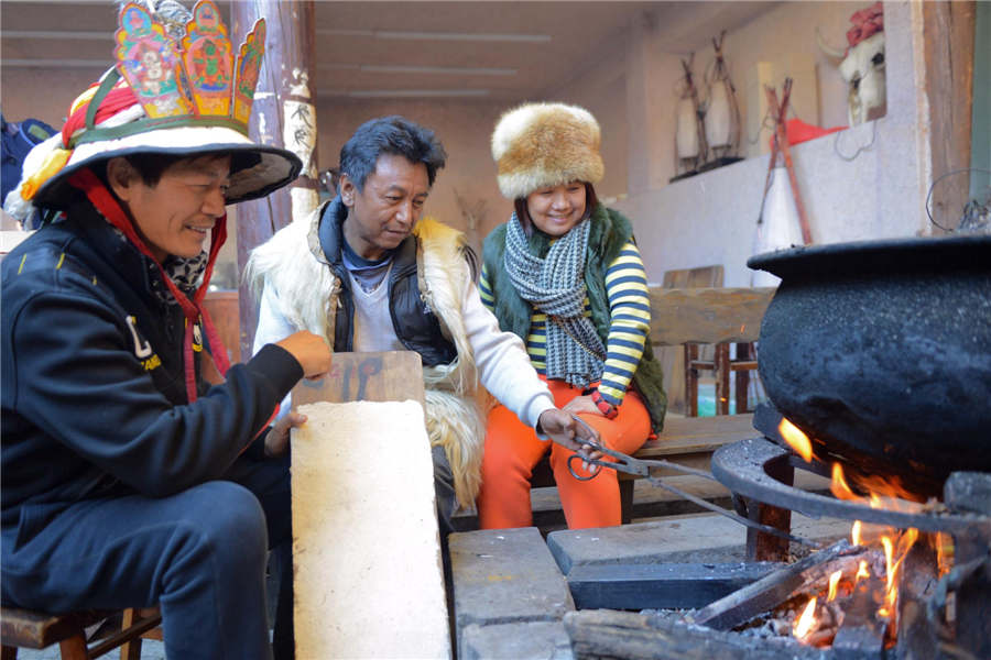 He Liwei (au centre), un héritier de la technique artisanale du papier Dongba, fait cuire des matières végétales. [Photo / Xinhua ]