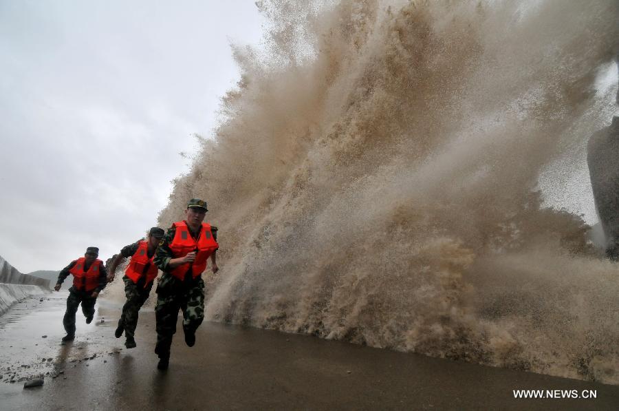 Typhon Fitow. Des soldats rencontrent les hautes vagues provoquées par le typhon Fitow à Wenling, dans la province du Zhejiang(est), le 6 octobre 2013. Les Autorités météorologiques de la Chine a émis une alerte rouge dimanche au typhon Fitow vers les zones côtières du sud-est du pays. (Xinhua/Jia Ce)