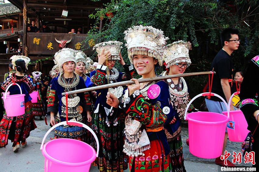 Une coutume pendant l'union des Miao et également une épreuve pour les jeunes mariées, où il s'agit de transporter deux seaux d'eau, pour prouver leur capacité à accomplir des travaux ménagers et entretenir une famille. (Photo/CNS/Li Xue)