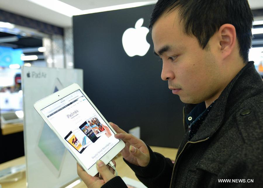 Un client regarde un iPad Mini Rétina sur un comptoir Apple magasin d'électroménager à Hangzhou, dans la province de Zhejiang(sudest de la Chine). L'iPad Mini avec écran Rétina est disponible en Chine depuis mardi après-midi dans la partie continentale en Chine.