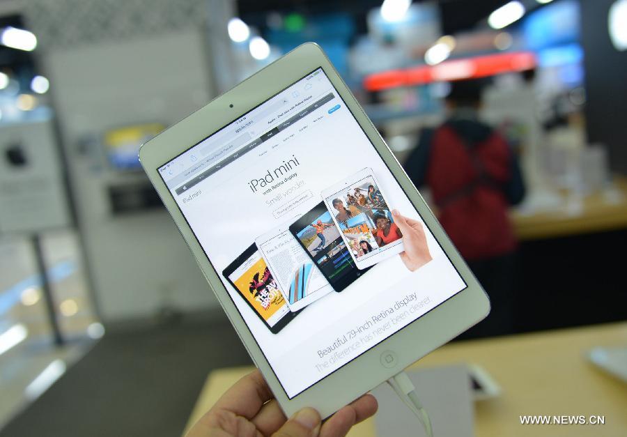 Un client regarde un iPad Mini Rétina sur un comptoir Apple magasin d'électroménager à Hangzhou, dans la province de Zhejiang(sudest de la Chine). L'iPad Mini avec écran Rétina est disponible en Chine depuis mardi après-midi dans la partie continentale en Chine.