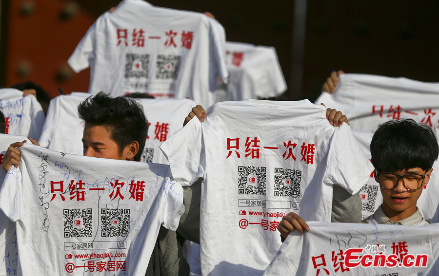 Des bénévoles montrent des T-shirt imprimés avec la phrase « Ne nous marions qu'une fois » à Nanjing, capitale de la Province du Jiangsu, dans l'Est de la Chine, le 17 novembre 2013. Plus de 100 résidents locaux et bénévoles ont pris part à une campagne lançant un appel pour des conceptions positives et saines du mariage dimanche à Nanjing. [Photo/China News Service]