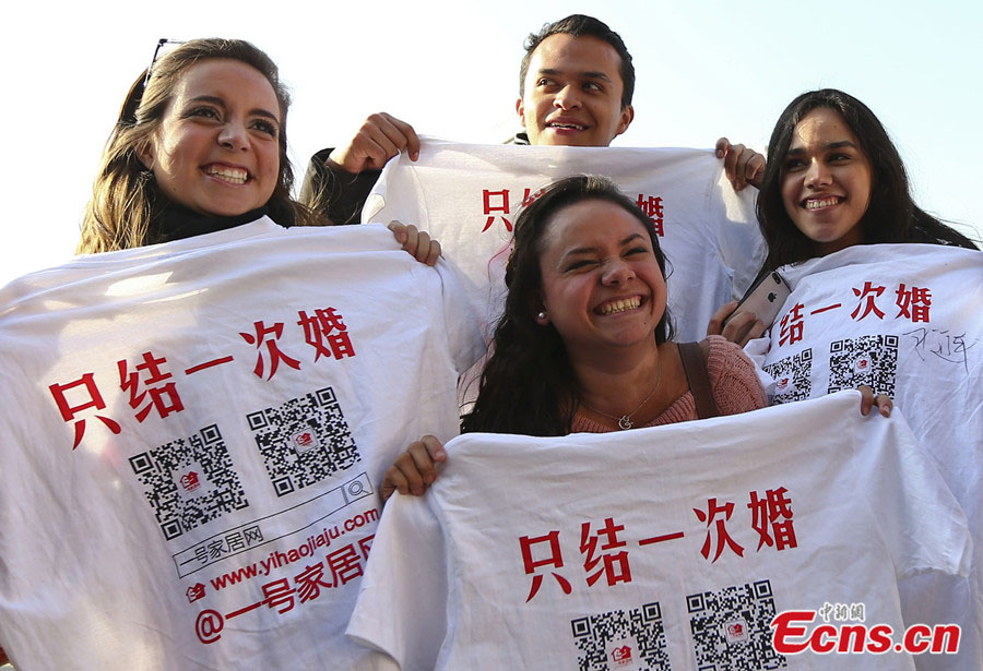 Des bénévoles montrent des T-shirt imprimés avec la phrase « Ne nous marions qu'une fois » à Nanjing, capitale de la Province du Jiangsu, dans l'Est de la Chine, le 17 novembre 2013. Plus de 100 résidents locaux et bénévoles ont pris part à une campagne lançant un appel pour des conceptions positives et saines du mariage dimanche à Nanjing. [Photo/China News Service]
