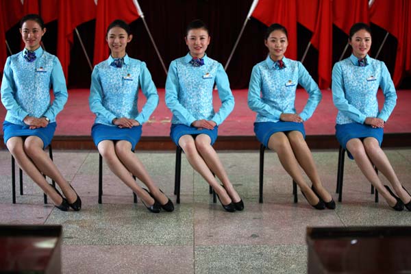 Des agents de bord ferroviaires montrent leur position assise standard lors d'un séminaire à Qingdao, dans la Province du Shandong, le 20 novembre 2013. [Photo Xu Chongde / Asianewsphoto]