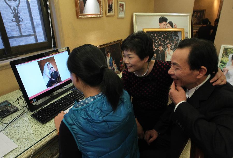 Le 20 novembre 2013 dans le Studio du Peuple de Shanghai, Monsieur Zhou et sa conjointe découvrent leurs nouvelles photos. 