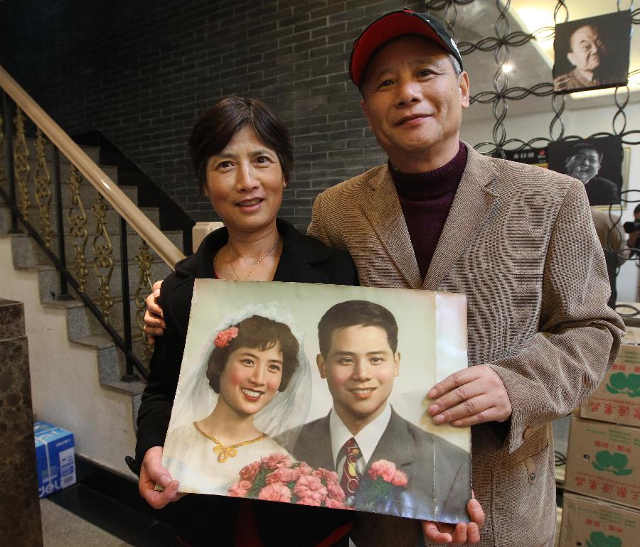 Le 20 novembre 2013 dans le Studio du Peuple de Shanghaï, Monsieur Zeng et son épouse montrent leur photo de mariage prise en 1979.