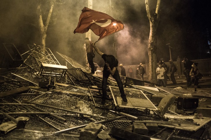 Le 1er juin 2013, à Istanbul, le gaz lacrymogène lancé par les forces de l'ordre force à reculer un manifestant agitant un drapeau. Photo prise par Daniel Etter.