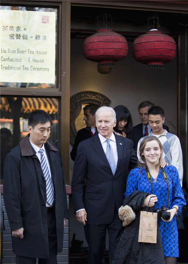 Le vice-président américain Joe Biden (centre) et sa petite-fille Finnegan Biden (droite) quittent un salon de thé, lors d' une visite des hutong à Beijing, le 5 décembre 2013. [Photo/agences]