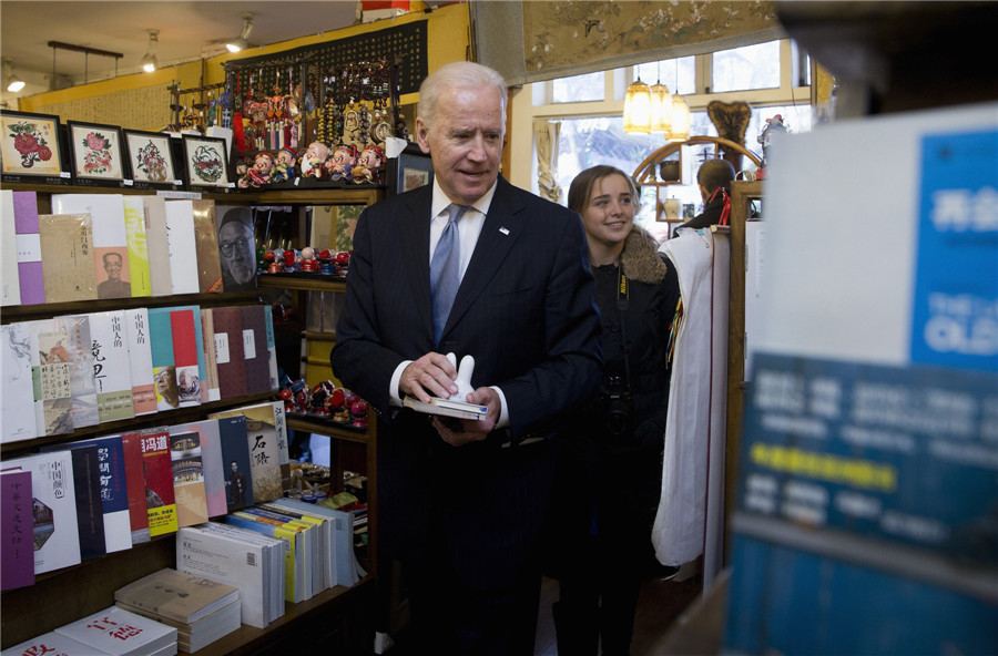 Le vice-président américain Joe Biden et sa petite-fille Finnegan Biden (G) font des achats dans une librairie de Beijing, le 5 décembre 2013. [Photo/agences]