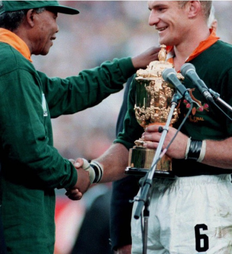 Le 24 juin 1995, Mandela, en maillot de l'équipe des Springboks, serre la main du capitaine de cette équipe, Francois Pienaar. Cela a été considéré comme une rupture de la séparation raciale. 