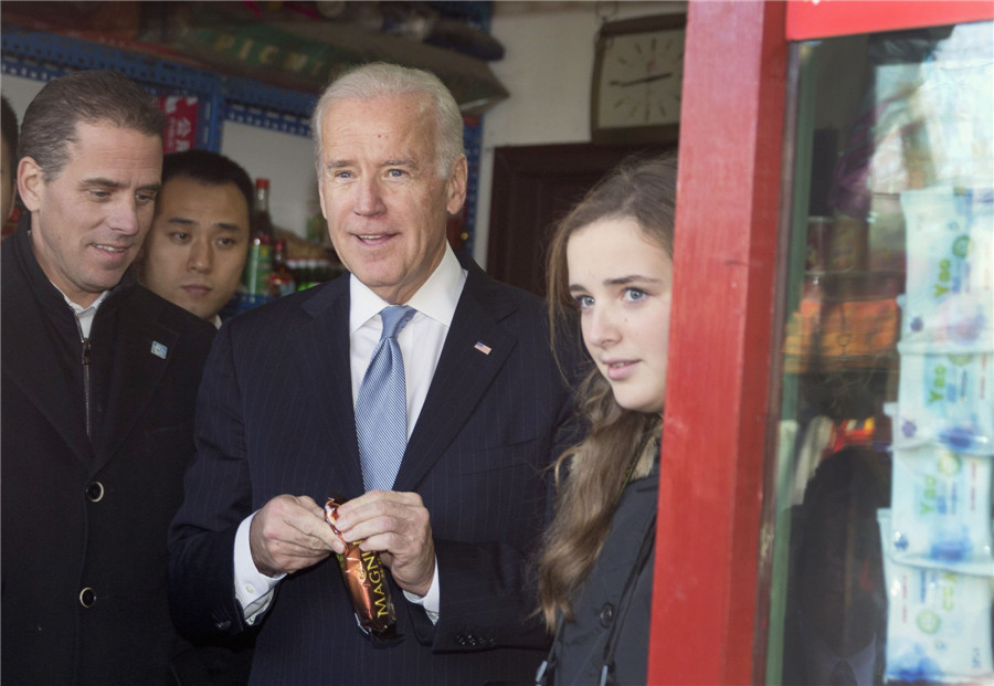 Le vice-président américain Joe Biden (centre) achète une glace dans un magasin, en parcourant une hutong avec sa petite-fille Finnegan Biden (droite) et son fils Hunter Biden à Beijing, le 5 décembre 2013. [Photo/agences]