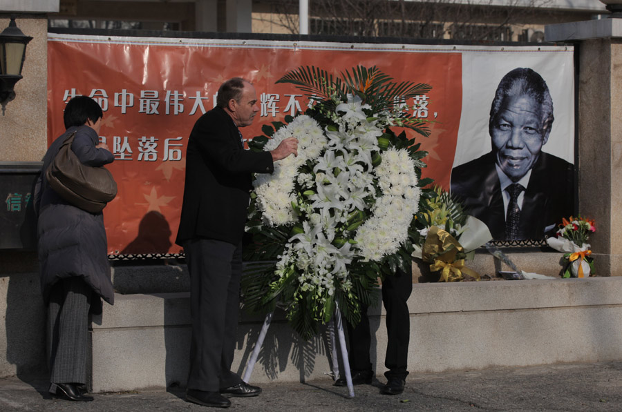 Des gens rendent hommage à l'ancien président sud-africain Nelson Mandela en face de l'ambassade d'Afrique du Sud à Beijing, le 6 décembre 2013. [Photo Wangjing / Asianewsphoto]