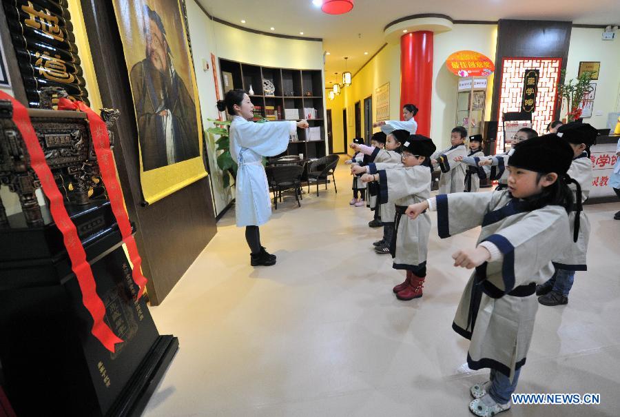 Des étudiants vêtus de costumes traditionnels de la dynastie des Han (202 BC- 220 AD) apprennent le wushu dans une école privée à Changsha, la capitale de la province du Hunan (centre de la Chine), le 7 décembre 2013. [Photo/Xinhua]