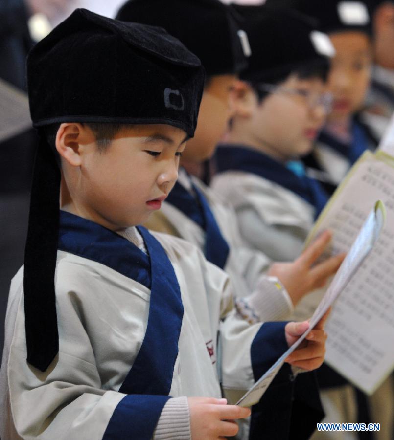 Des étudiants portent des costumes traditionnels de la dynastie des Han ( 202 BC- 220 AD ) en pleine lecture dans une école privée à Changsha, la capitale de la province du Hunan (centre de la Chine), le 7 décembre 2013. [Photo/Xinhua]