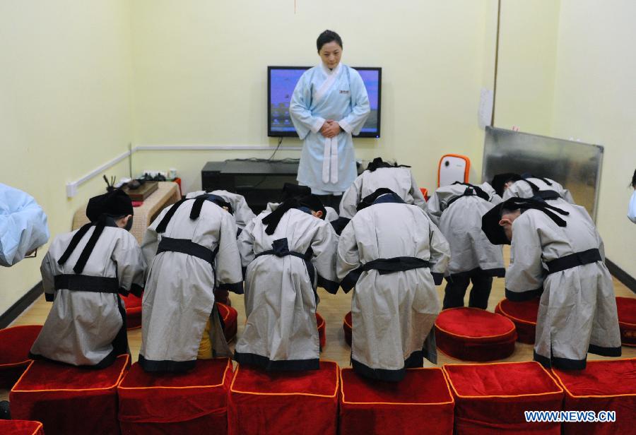 Des étudiants vêtus de costumes traditionnels de la dynastie Han (202 BC- 220 AD) saluent un enseignant dans une école privée à Changsha, capitale de la province du Hunan en Chine centrale 7 Déc 2013. [Photo/Xinhua]