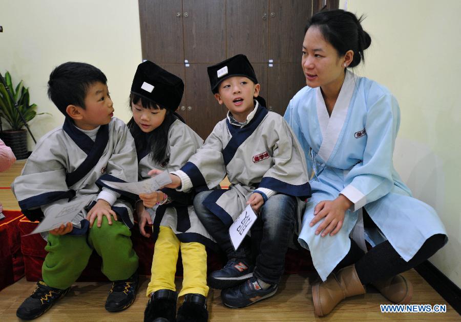 Des jeunes élèves vêtus de costumes traditionnels de la dynastie des Han (202 BC- 220 AD) en pleine conversation avec leur professeur dans une école privée à Changsha, la capitale de la province du Hunan (centre de la Chine), le 7 décembre 2013. [Photo/Xinhua]