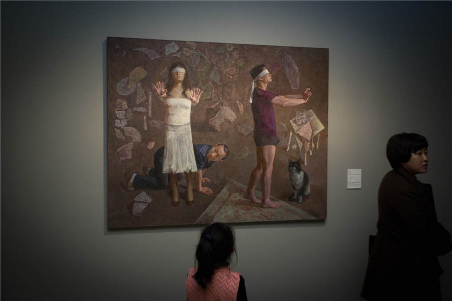 Une jeune fille admire une peinture à l'exposition d'art présentant des œuvres des professeurs de l'ACBC à l'Académie Centrale des Beaux-Arts de Chine. [Photo fournie au  China Daily]