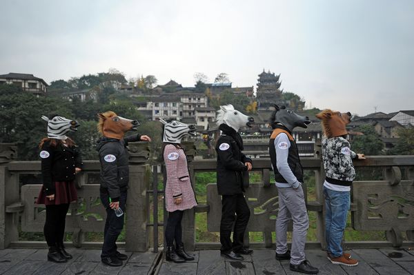 Des artistes portant une tête de cheval à Ciqikou, une ancienne ville du district de Shapingba, la municipalité de Chongqing le 10 déc 2013.