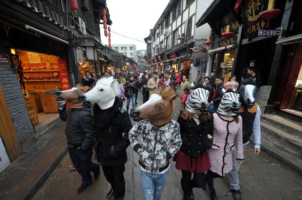 Une équipe d'artistes portant une tête de cheval dans les rues de Ciqikou , une ancienne ville dans le district de Shapingba de la municipalité de Chongqing le 10 déc 2013.