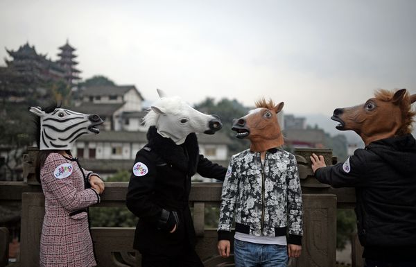 Des artistes portant une tête de cheval à Ciqikou, une ancienne ville du district de Shapingba, la municipalité de Chongqing le 10 déc 2013.