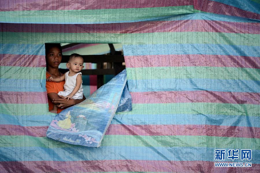 Le 27 novembre 2013, la ville phillipine de Tacloban, impitoyablement balayée par le super-typhon Haiyan, un garçon et son petit frère se retrouvent dans une tente de fortune. (Photo : Xinhua/AFP)