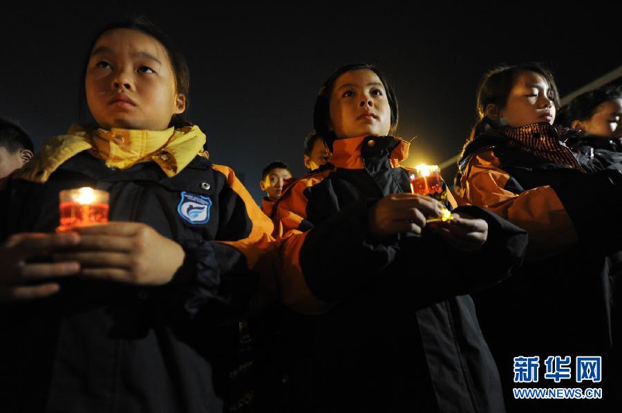 Jeudi 12 décembre au Mémorial des victimes du massacre de Nanjing, des écoliers, une bougie à la main, prient pour les disparus. (Photo : Xinhua/Han Yuqing)