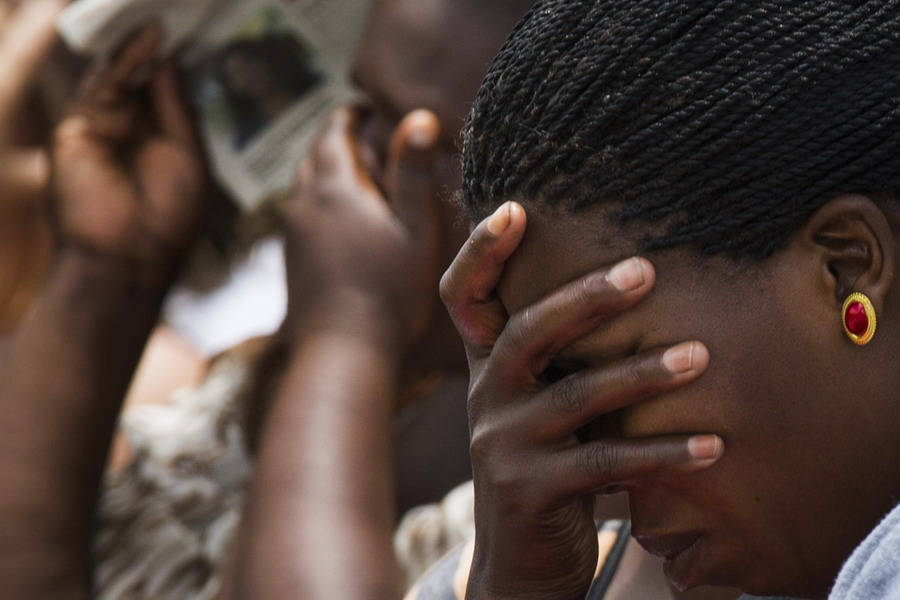 Des villageois réagissent en regardant le corps de Nelson Mandela passant vers son dernier lieu de repos, lors d'une grande retransmission publique du haut d'une colline à proximité de Qunu, en Afrique du Sud, le 15 Décembre 2013. 