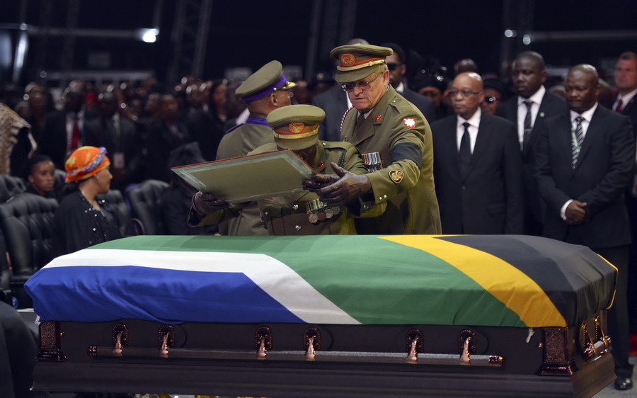Des officiers posent un cadre sur le cercueil de l'ancien président sud-africain Nelson Mandela lors de la cérémonie de funérailles à Qunu, le 15 décembre 2013. 